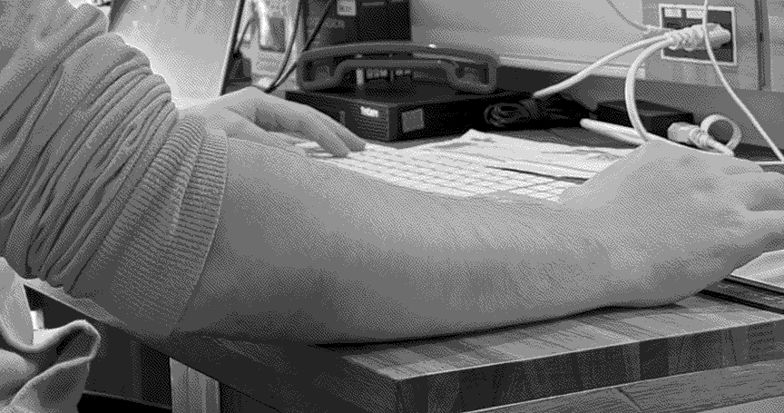 a workstation with a pcb, multimeter, and other tools